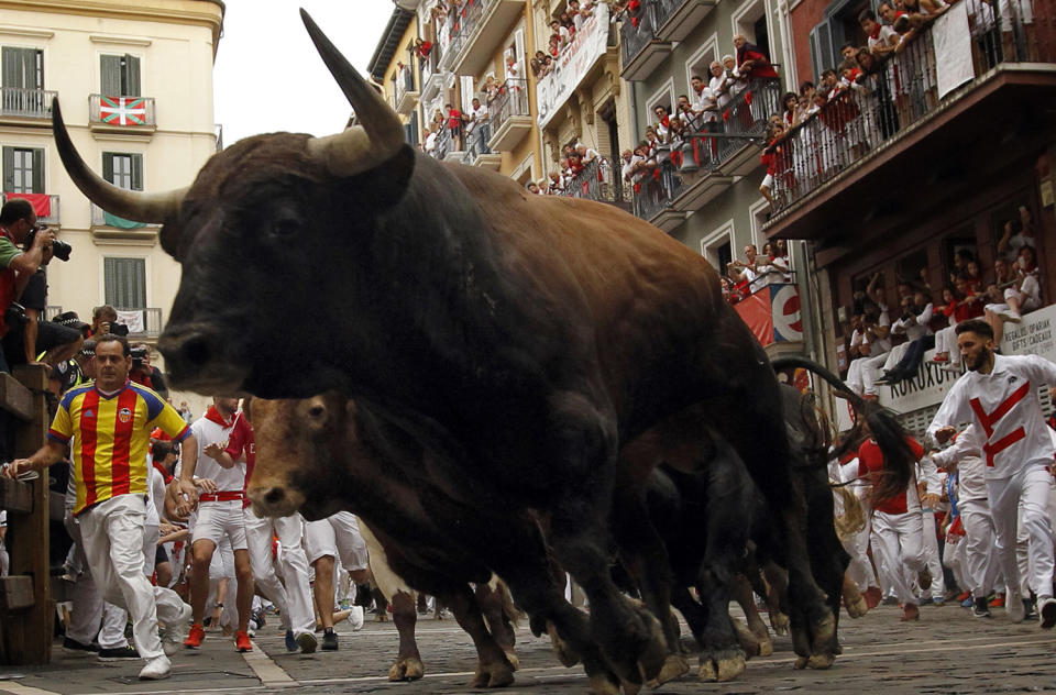 <p>Revellers run next to Nunez del Cuvillo’s fighting bulls during the running of the bulls at the San Fermin Festival, in Pamplona, northern Spain, July 13, 2017. (Photo: Alvaro Barrientos/AP) </p>