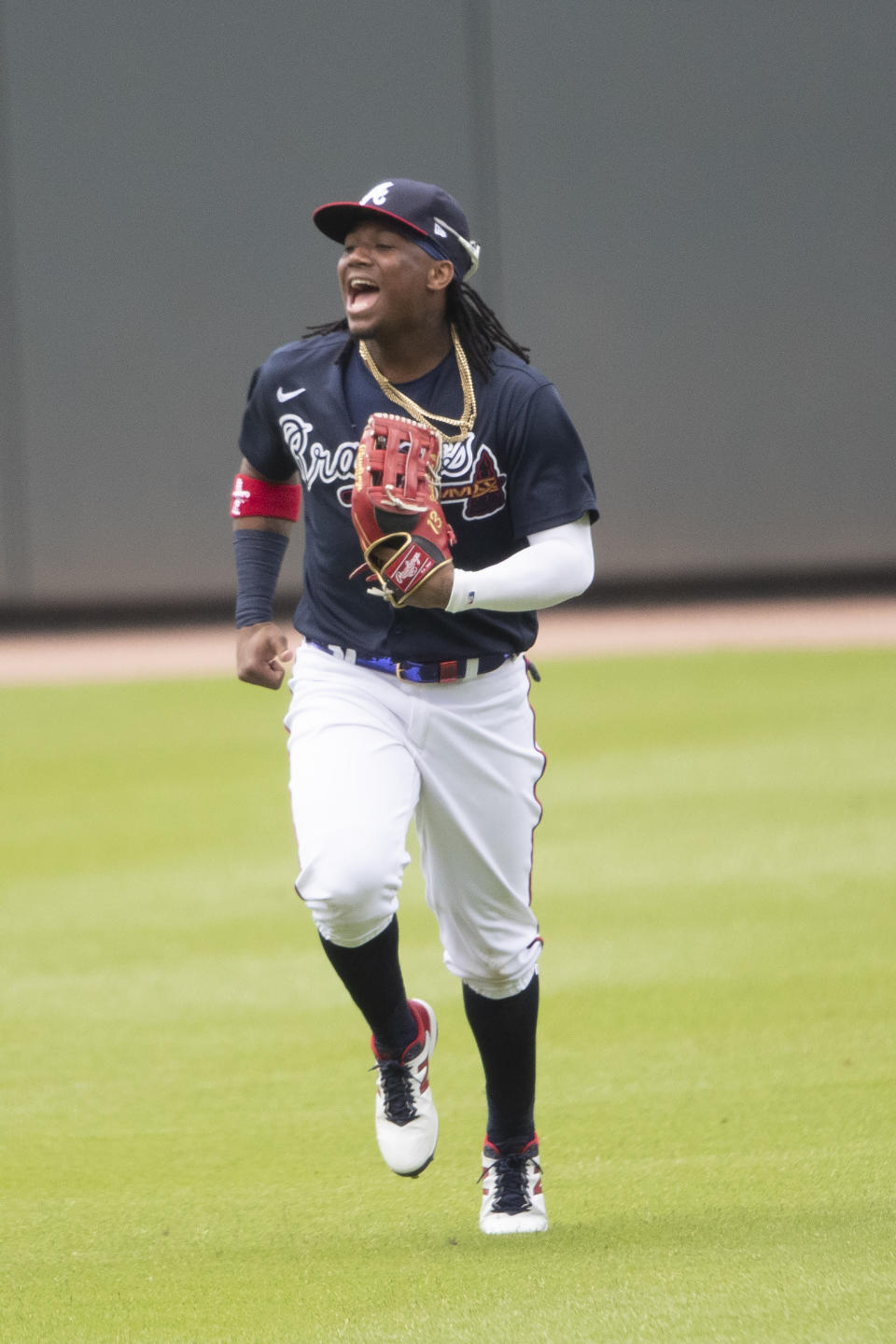 Atlanta Braves center fielder Ronald Acuna Jr. (13) jokes with teammates as he runs in from the outfield during a practice baseball game, Thursday, July 9, 2020, in Atlanta. (AP Photo/John Bazemore)