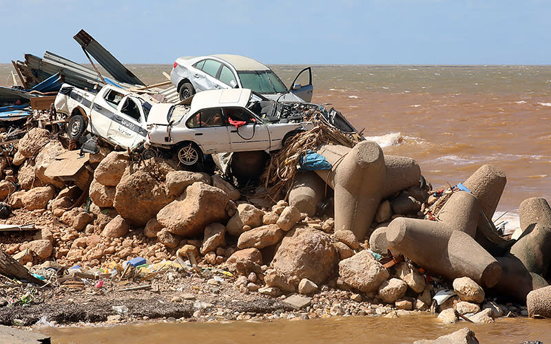 Cars are piled up atop wave breakers and the rubble of a building destroyed in flash floods Sept. 14 after the Mediterranean storm Daniel hit Libya’s eastern city of Derna. A global aid effort for Libya gathered pace after a tsunami-sized flash flood killed at least 4,000 people, with thousands more missing, a death toll the U.N. blamed in part on the legacy of years of war and chaos. <em>Abdullah Doma/AFP via Getty Images</em>