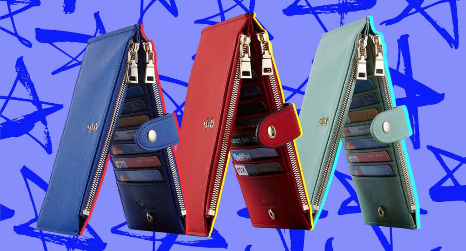 Three wallets shown standing like a tent, navy on the left, red in the center, and sage green on the right.  Each has two zipper pockets, a snap closure and multiple card slots.