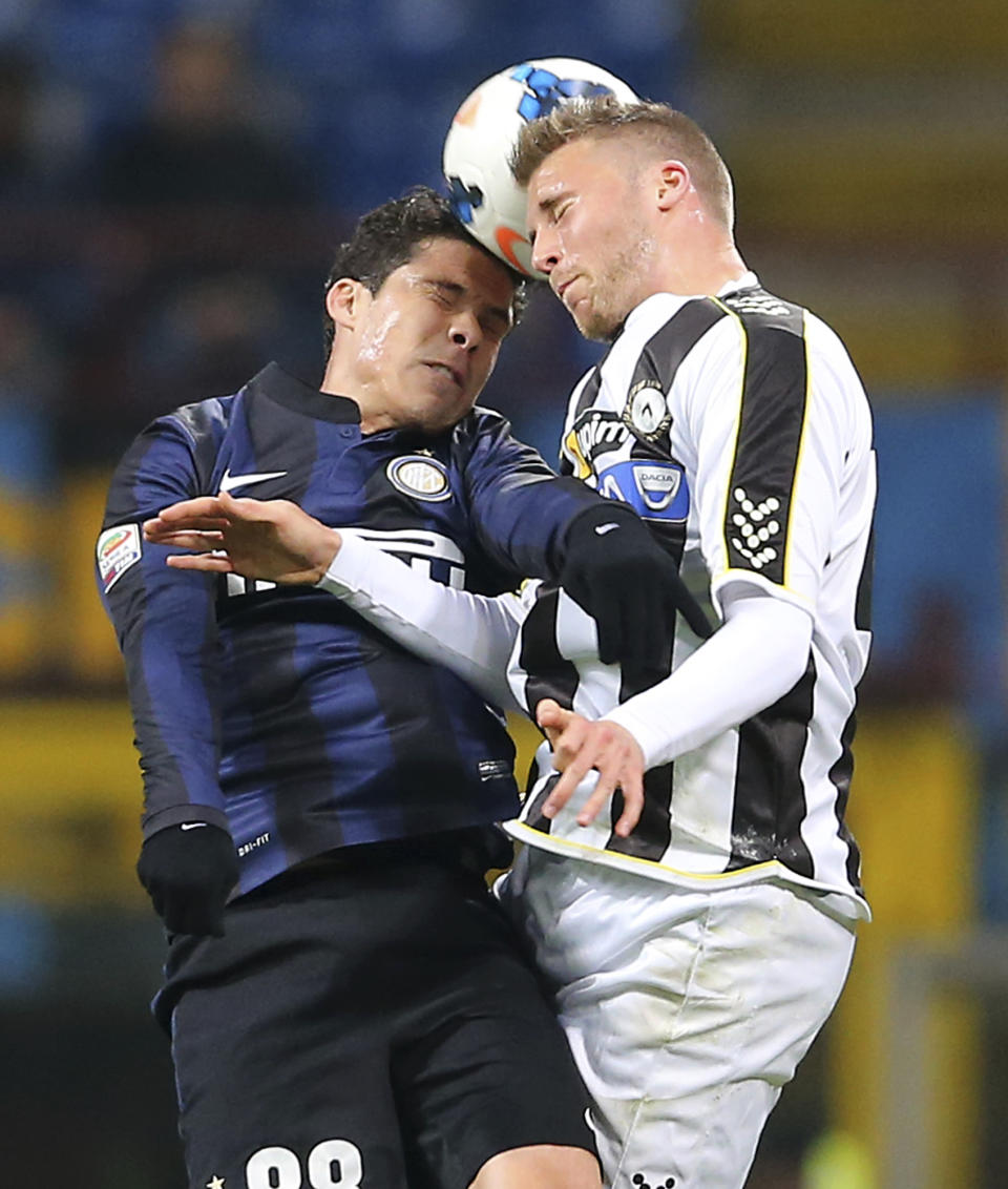 Inter Milan Brazilian midfielder Anderson Hernanes, left, jumps for the ball with Udinese defender Silvan Widmer, of Switzerland, during the Serie A soccer match between Inter Milan and Udinese at the San Siro stadium in Milan, Italy, Thursday, March 27, 2014. (AP Photo/Antonio Calanni)