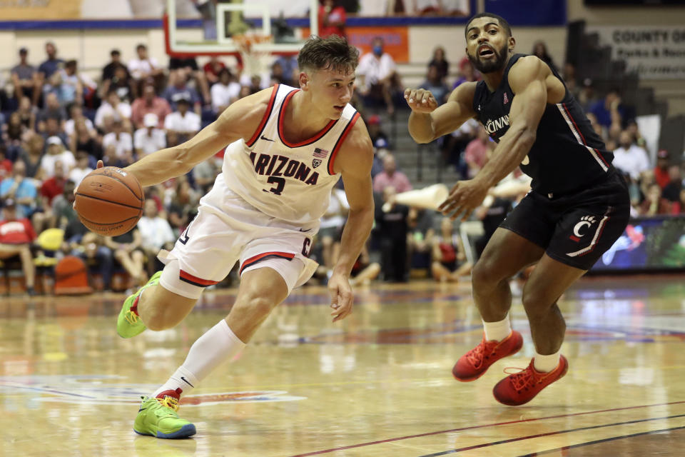 Cincinnati guard David DeJulius (5) chases Arizona guard Pelle Larsson (3) during the second half of an NCAA college basketball game, Monday, Nov. 21, 2022, in Lahaina, Hawaii. (AP Photo/Marco Garcia)