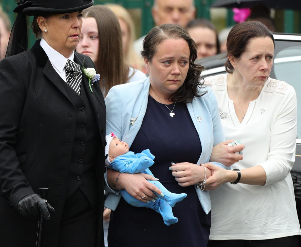 Mylee Billingham’s mother Tracey Taundry holding a doll as she arrived at the funeral of the eight-year-old (PA Images)