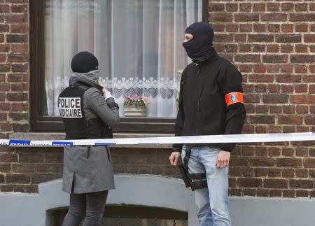 Belgian and French police secure access during a police operation to search an apartment complex in the Brussels district of Uccle, Belgium, April 12, 2016. REUTERS/Yves Herman