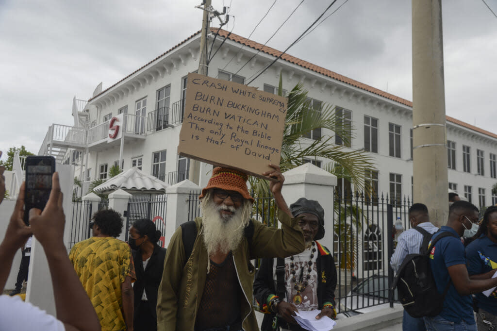 People protest to demand an apology and slavery reparations during a visit to the former British colony by the Duke and Duchess of Cambridge, Prince William and Kate, in Kingston, Jamaica, Tuesday, March 22, 2022. The two-day visit to Jamaica is part of a larger trip to the Caribbean region encouraged by Queen Elizabeth II as some countries debate cutting ties with the monarchy like Barbados did late last year. (AP Photo/Collin Reid)