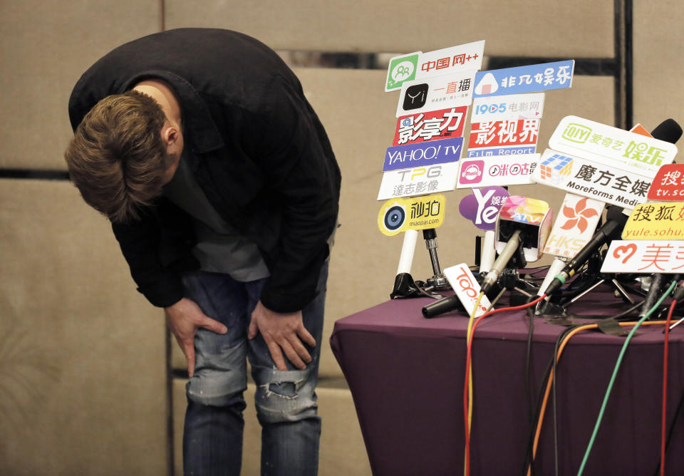 Hong Kong singer Andy Hui bows after a press conference about his affair in Hong Kong, Tuesday, April 16, 2019. Hong Kong's Apple Daily newspaper published video that purported to show Andy Hui being intimate in a taxi with another Hong actress, decades younger than him, Jacqueline Wong. (AP Photo/Vincent Yu)
