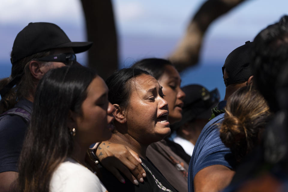 Lahaina, Hawaii, residents sing a song as they gather for a news conference in Lahaina, Hawaii, Friday, Aug. 18, 2023. (AP Photo/Jae C. Hong)