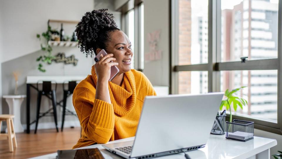 How to make money as a stay at home mom: Black woman talking on the phone at home