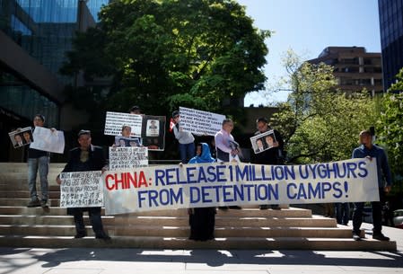 FILE PHOTO: People hold signs protesting China's treatment of the Uighur people, in Vancouver, British Columbia, Canada