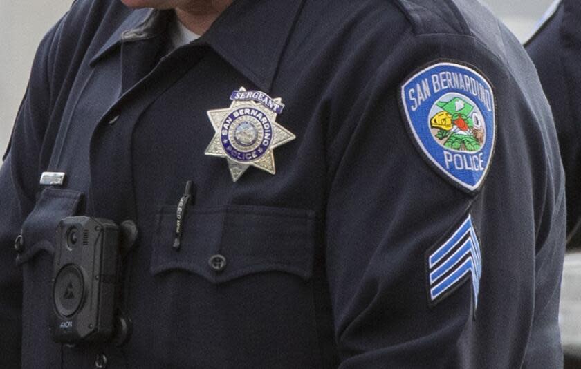 HIGHLAND, CA - AUGUST 18, 2021: San Bernardino Police Officers huddle over the hood of a patrol vehicle near the scene where two San Bernardino Police Officers were wounded in a shootout with a suspect who was allegedly involved in shooting a San Bernardino County Sheriff Deputy the day before on August 18, 2021 in Highland, California. The suspect died at the scene.(Gina Ferazzi / Los Angeles Times)