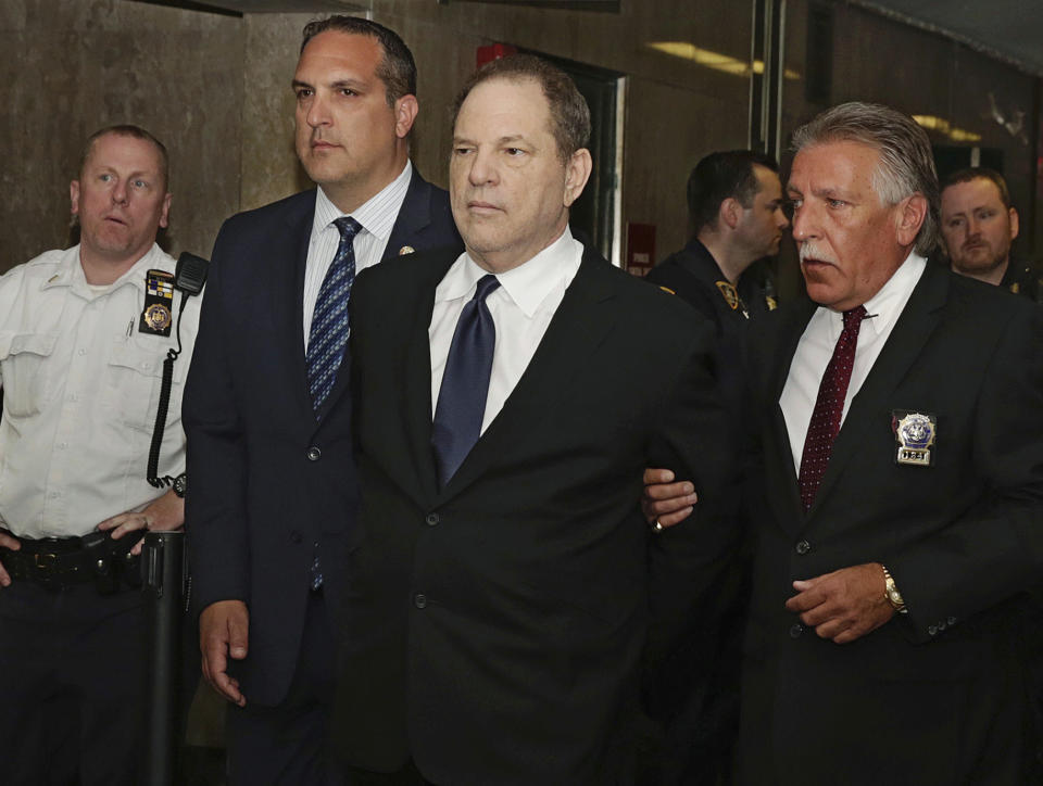 FILE - In this July 9, 2018 file photo, Harvey Weinstein is escorted in handcuffs to a courtroom in New York. The #MeToo movement has sent dozens of once-powerful men in Hollywood into exile, but it has yet to put many of them in handcuffs or courtrooms. Weinstein has been charged with sexual assault in New York and Bill Cosby has been sent to prison in Pennsylvania in the year since stories on Weinstein in The New York Times and The New Yorker set off waves of revelations of sexual misconduct in Hollywood. But those two central figures have been exceptions. (AP Photo/Richard Drew, File)