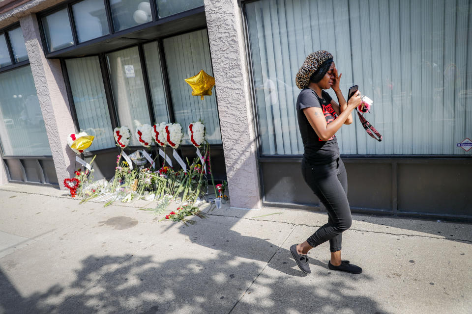 A mourner leaves a makeshift memorial Tuesday, Aug. 6, 2019, for the slain and injured in the Oregon District after a mass shooting that occurred early Sunday morning, in Dayton. (AP Photo/John Minchillo)