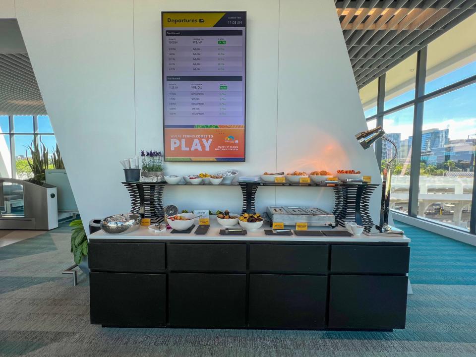 A buffet bar with fruits, breads and other snacks is shown.