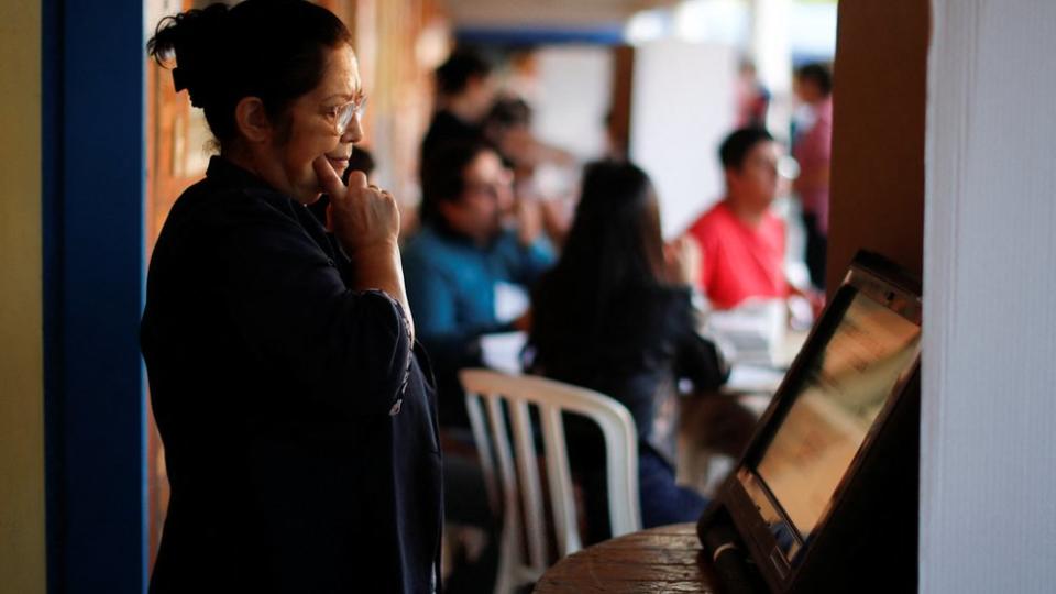 Mujer frente a un tablero electronico