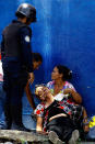 <p>A woman is overcome by tear gas that was used to disperse the relatives of prisoners who were waiting to hear news about their family members imprisoned at a police station where a riot broke out, in Valencia, Venezuela, Wednesday, March 28, 2018. In a state police station housing more than one hundred prisoners, a riot culminated in a fire, requiring authorities to open a hole in a wall to rescue the inmates. (Photo: Juan Carlos Hernandez/AP) </p>