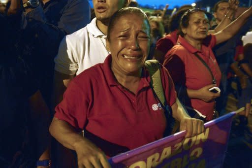 Photo Par Juan Barreto - "J'ai le coeur détruit, c'est comme si j'avais perdu un père ou un fils", confie Ariani Rodríguez, devant la porte de l'hôpital militaire de Caracas où des centaines de militants pleurent la mort du président Hugo Chavez, décédé dans l'après-midi