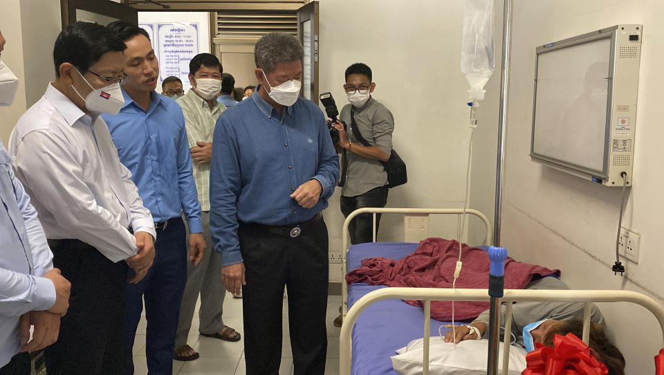 In this photo provided by the Preah Sihanouk Provincial Administration, Huoch Chamroeun, center, Governor of Preah Sihanouk Province and Chinese Ambassador to Cambodia Wang Wentian, left, visit Chinese survivors rescued from a sinking boat as the recuperate in the hospital of Preah Sihanouk Province, southwestern Cambodia on Saturday, Sept. 24, 2022. Authorities are searching for multiple people in the Gulf of Thailand after their boat sank near Cambodia's Koh Tang island on Thursday. (Preah Sihanouk Provincial Administration via AP)