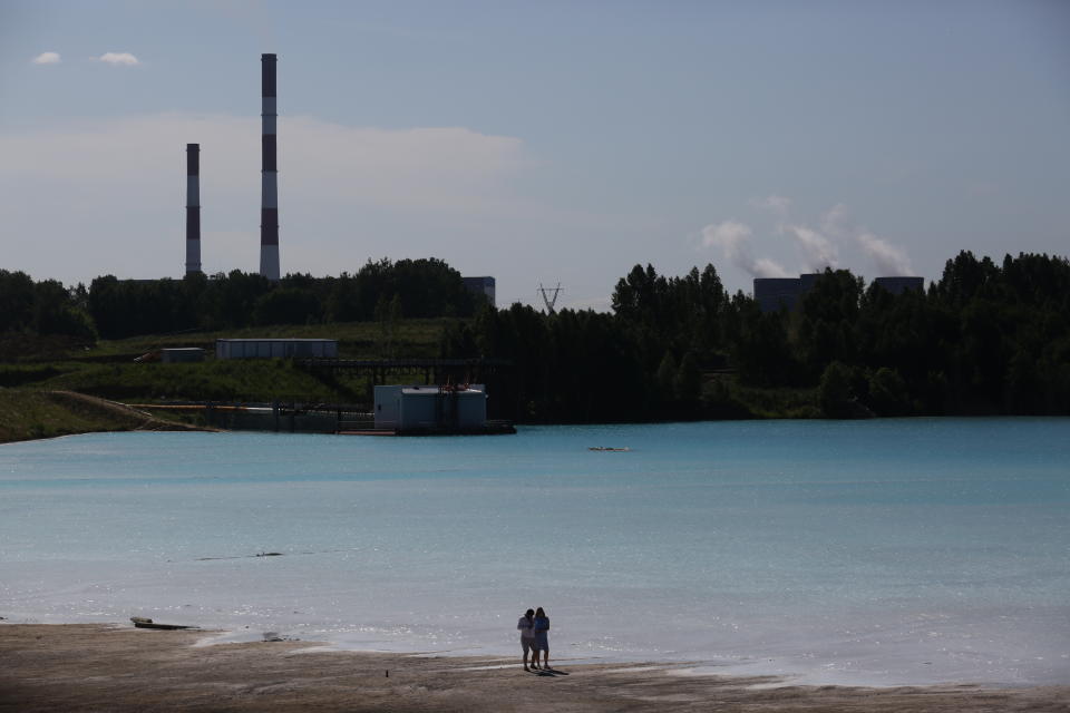 A couple walks by a Novosibirsk energy plant's ash dump site - nicknamed the local "Maldives" - on July 11, 2019. (Photo: Rostislav Netisov/AFP/Getty Images)