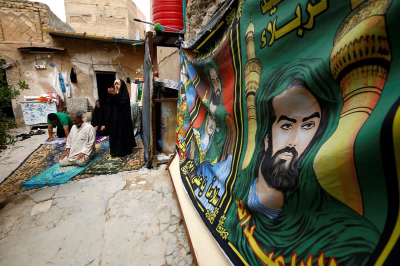 Family pray at home, as Friday prayers were suspended following the spread of the coronavirus disease (COVID-19), in the holy city of Najaf