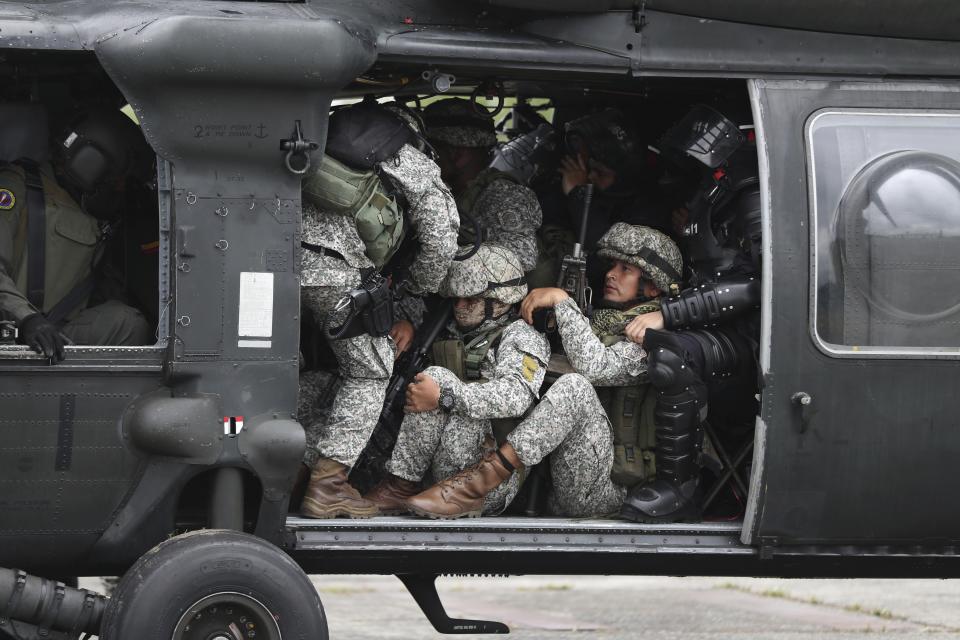 Soldiers and National Police crowd into a helicopter as they prepare to lift off and travel to an illegal gold mining operation to destroy as part of the Armed Forces' "Operation Guamuez III" in Magui Payan, Colombia, Tuesday, April 20, 2021. Illegal gold mining is common in Colombia, especially wildcat mines in poverty-stricken areas dominated by criminal gangs with little state presence. (AP Photo/Fernando Vergara)