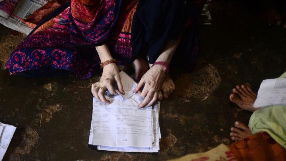 An Indian Muslim woman makes paper bags at her home to sell them to shopkeepers in Allahabad on July 15, 2018. - The Uttar Pradesh government has banned the use of polythene bags and common items made of plastic from July 15th.