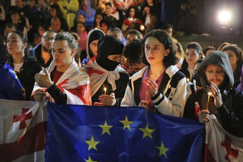 Demonstrators with Georgian and EU flags holding candles stand in front of the Kashveti Church during a protest against "the Russian law" in Tbilisi, Georgia on May 3, 2024.