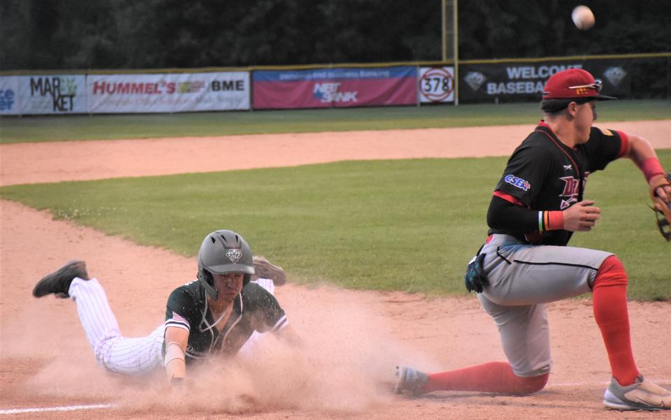 Pinch runner Nick Sturino dives into third base with a stolen base as the throw skips away from Glens Falls third baseman Nick Marola during the eighth inning of the Mohawk Valley DiamondDawgs' Tuesday game in Little Falls.