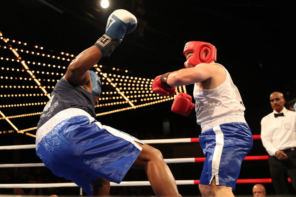 <p>Andre Smith, left, falls backward after being hit by Vincent Trozzi during the NYPD Boxing Championships at the Theater at Madison Square Garden on June 8, 2017.(Photo: Gordon Donovan/Yahoo News) </p>