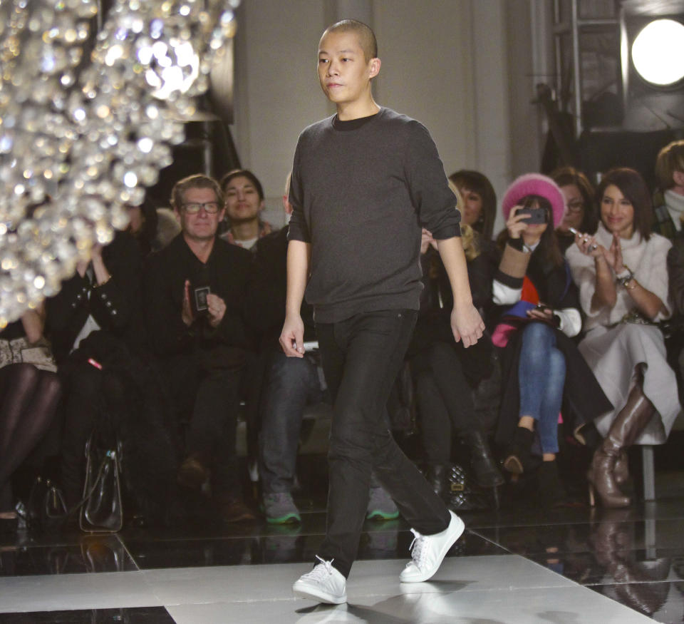 Fashion designer Jason Wu walks onto the runway to applause after showing his Fall 2013 collection on Friday, Feb. 8, 2013 in New York. (AP Photo/Bebeto Matthews)