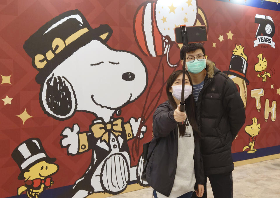 People wearing face masks to help curb the spread of the coronavirus visit the popular cartoon dog Snoopy's 70th Anniversary Exhibition in Taipei, Taiwan, Saturday, Feb, 20, 2021. (AP Photo/Chiang Ying-ying)