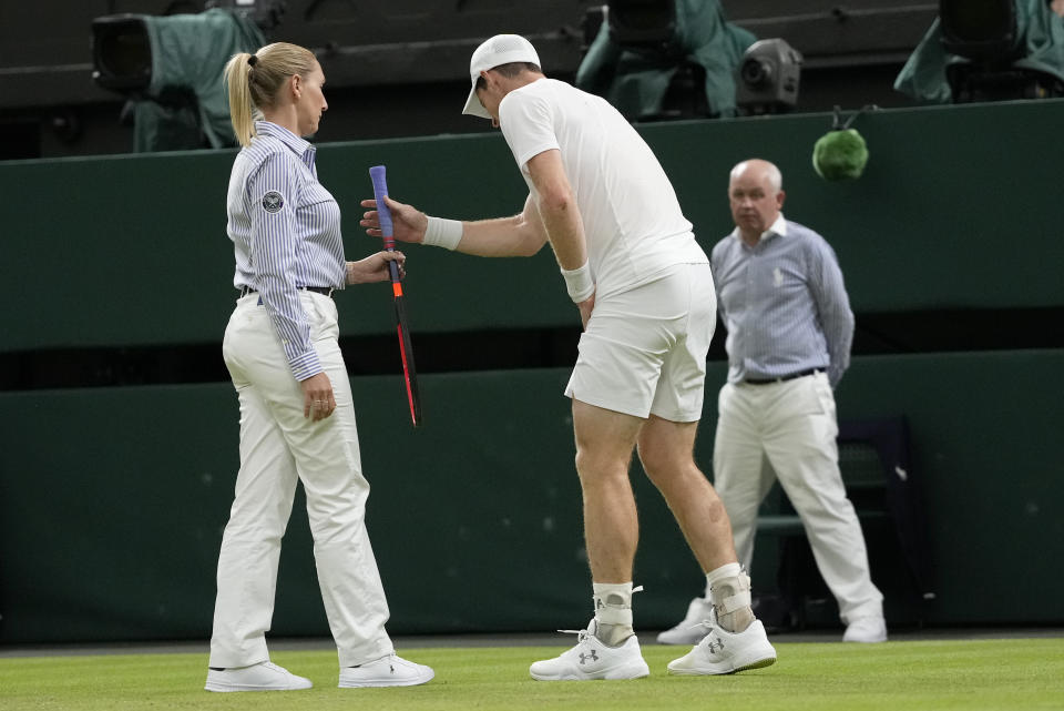 Britain's Andy Murray is assisted after slipping and falling trying to play a shot to Stefanos Tsitsipas of Greece in a men's singles match on day four of the Wimbledon tennis championships in London, Thursday, July 6, 2023. (AP Photo/Kirsty Wigglesworth)