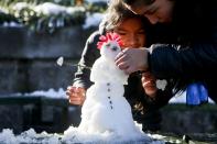 <p>Mädchen bauen in der chilenischen Hauptstadt Santiago einen Schneemann. Am Wochenende kam es in der Stadt zu den heftigsten Schneefällen der jüngeren Geschichte. (Bild: AP Photo/Esteban Felix) </p>