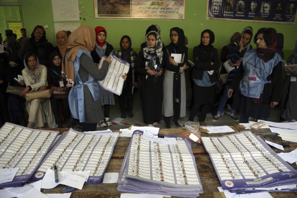 Afghan election workers count ballots during the parliamentary elections at a polling station in Kabul, Afghanistan, Sunday, Oct. 21, 2018. Te elections entered a second day after delays caused by violence and technical issues, as a roadside bomb killed nearly a dozen civilians on Sunday, including several children. (AP Photo/Rahmat Gul)