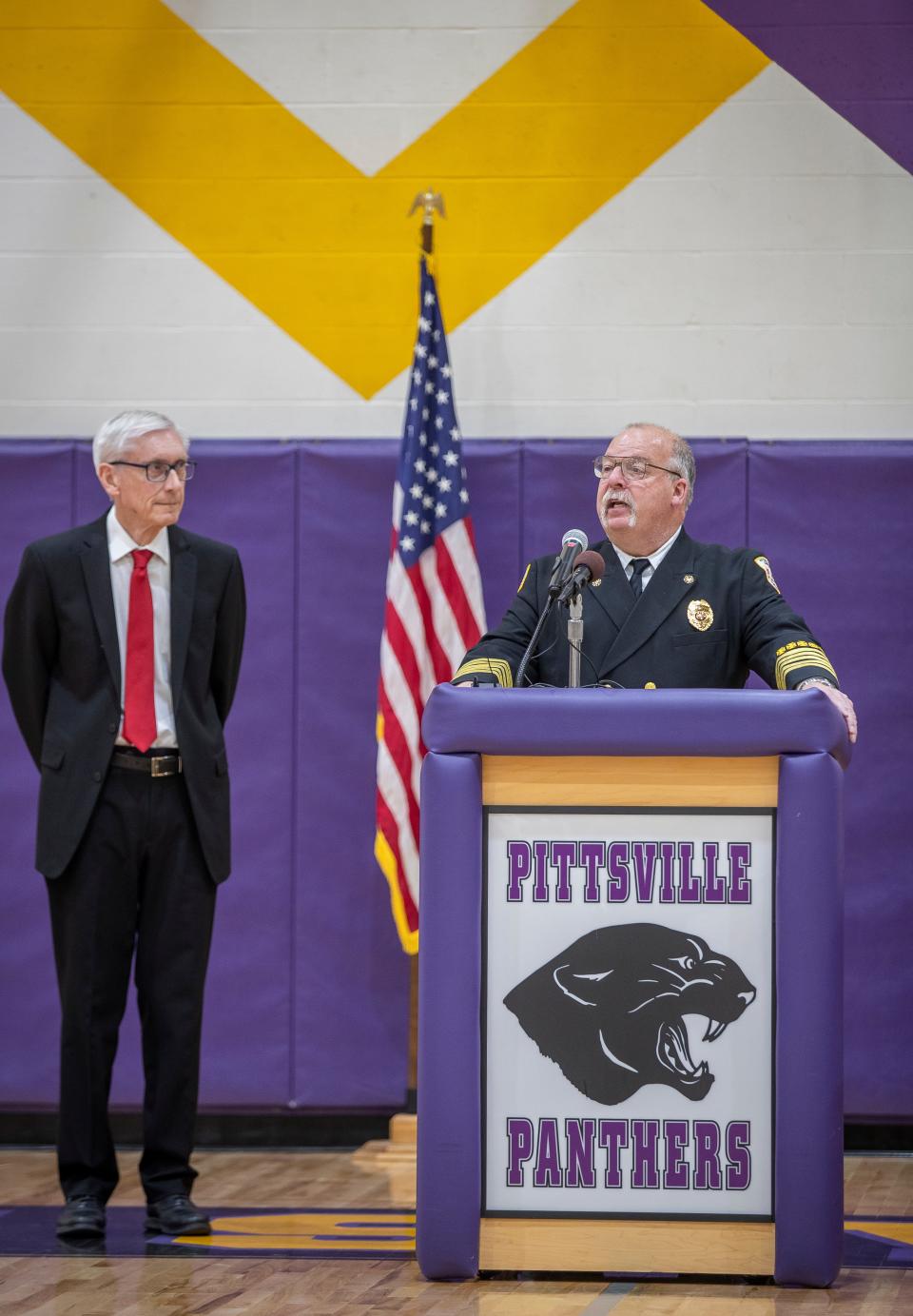 Pittsville Fire Chief Jerry Minor gives a brief speech about the the counterfeit and nuisance lighter bill he has made efforts of creating into law for sixteen years as Wisconsin governor Tony Evers stands to the side and awaits to sign said bill into law at Pittsville Elementary School in Pittsville, Wisconsin on Friday, April 5, 2024.