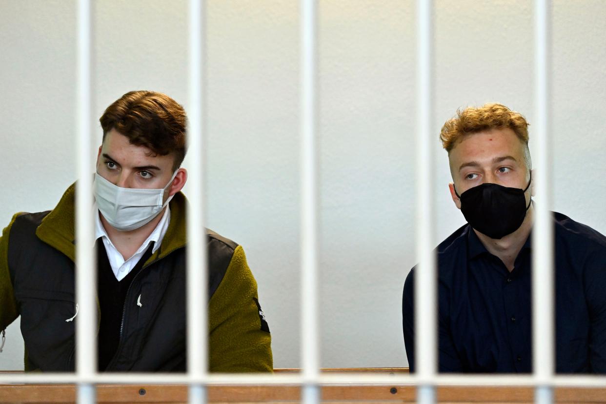 Gabriel Natale-Hjorth (left) and Finnegan Lee Elder wear face masks to curb the spread of COVID-19 as they sit bars inside the courtroom in Rome on March 1, 2021.