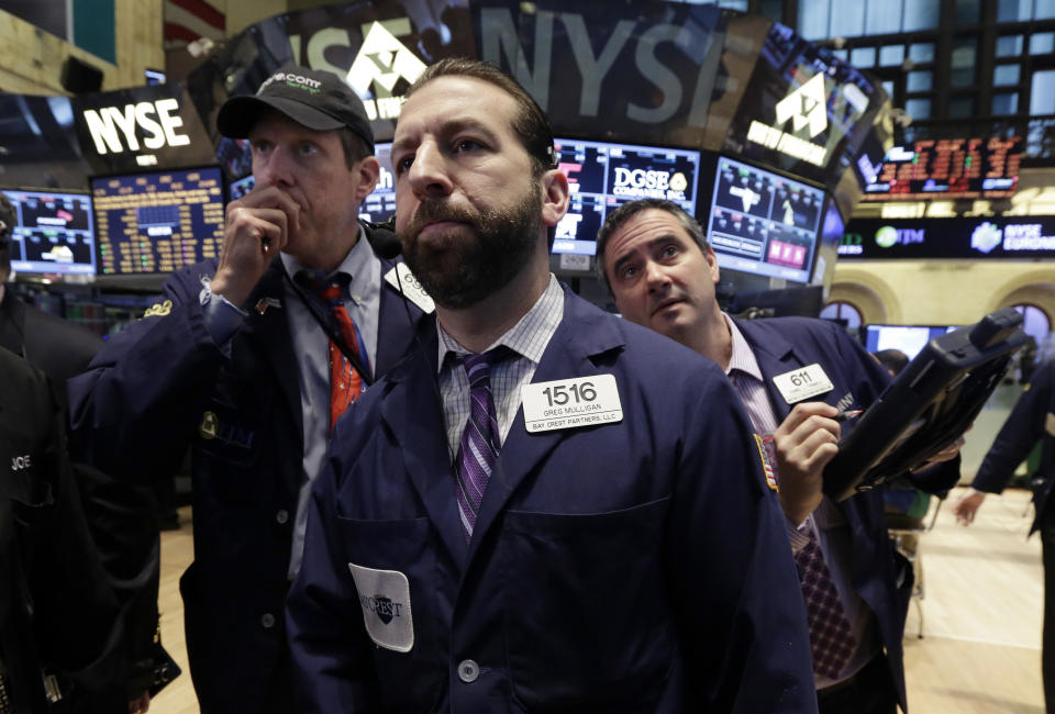 Greg Mulligan, center, works with fellow traders on the floor of the New York Stock Exchange Wednesday, Feb. 5, 2014. The U.S. stock market is edging lower in early trading after a modest recovery the day before. (AP Photo/Richard Drew)