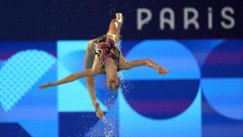 A member of Egypt's artistic swimming team does a daring tumble at the Paris Olympics in France - Wednesday 7 August 2024 