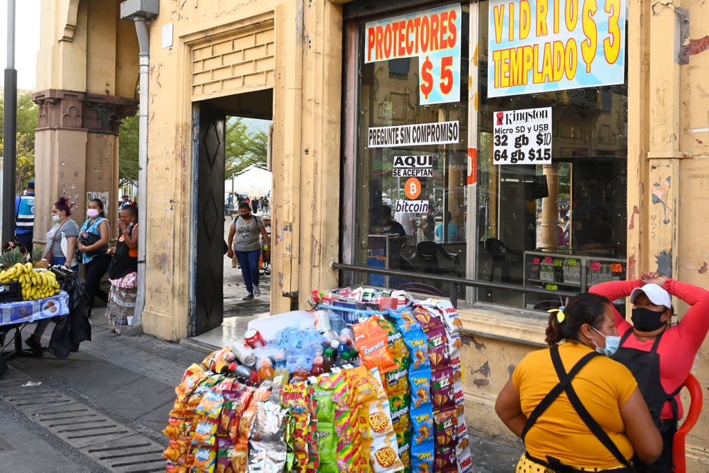 A signal that reads ‘We accept bitcoin here’ is seen outside a store in San Salvador (AFP via Getty Images)