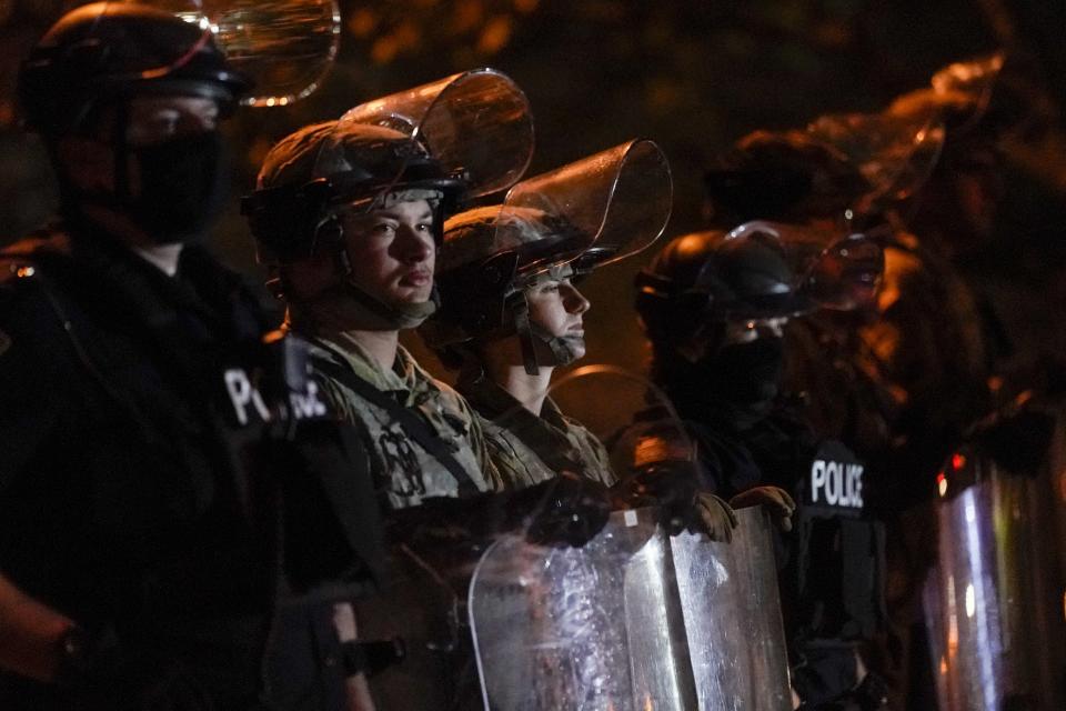 CORRECTS TO JOHN CHISHOLM NOT JOHN CHISOLM - Police and National Guardsmen line up in riot gear Friday, Oct. 9, 2020, in Wauwatosa, Wis. On Wednesday, District Attorney John Chisholm refused to issue charges against Wauwatosa Police Officer Joseph Mensah for the Feb. 2 fatal shooting of 17-year-old Alvin Cole at Mayfair Mall. (AP Photo/Morry Gash)