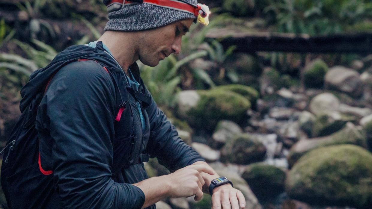  Trail runner monitoring health data during workout . 