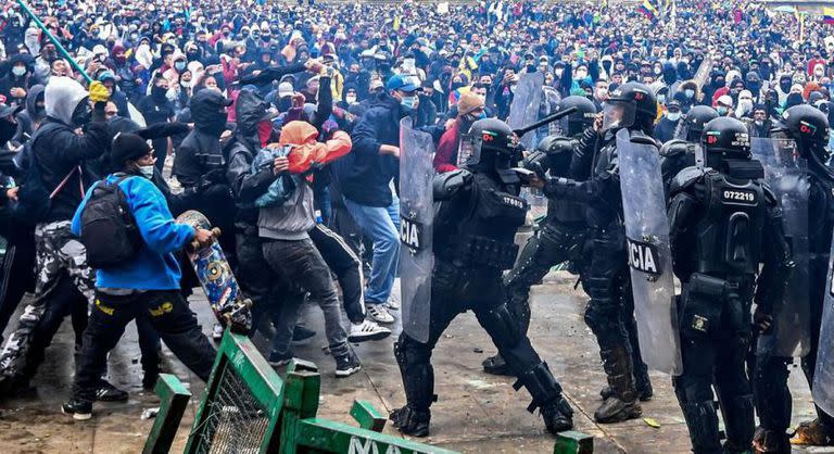 Manifestantes chocan con la policía antidisturbios durante una protesta contra un proyecto de reforma tributaria lanzado por el presidente colombiano Iván Duque, en Bogotá, Colombia (AFP/ Juan Barreto)