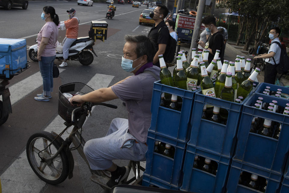 A delivery man transports beer on the streets of Beijing on Tuesday, July 14, 2020. China's economy rebounded from a painful contraction to grow by 3.2% over a year earlier in the latest quarter as anti-virus lockdowns were lifted and factories and stores reopened. (AP Photo/Ng Han Guan)