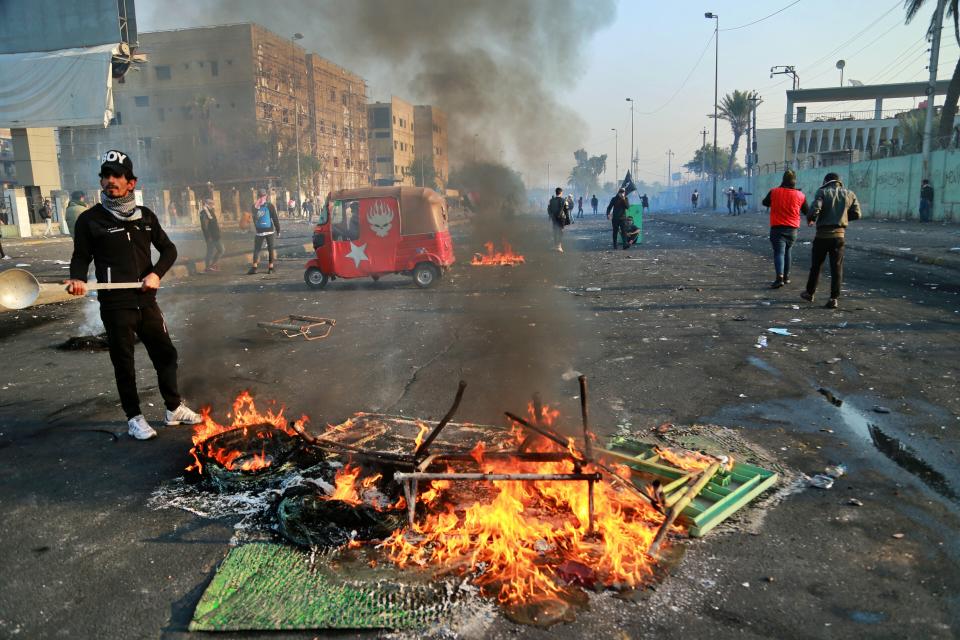 Anti-government protesters set fire and close streets while security forces use tear gas during ongoing protests in central Baghdad, Iraq, Monday, Jan. 20, 2020. (AP Photo/Hadi Mizban)