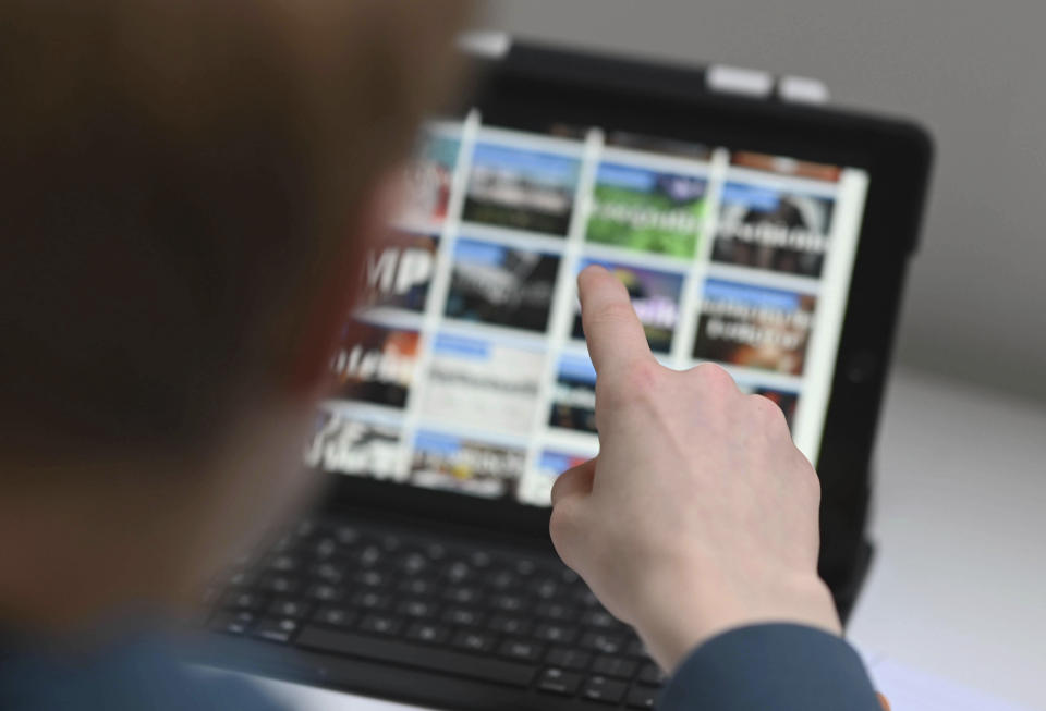 A person points on a tablet computer in Karlsruhe, Germany, Wednesday, Jan. 20, 2021. The German government on Wednesday agreed on a strategy to boost the use of data for commercial purposes and signed a deal with state education authorities to fund laptops for teachers who have to work from home because of the virus lockdown. (Uli Deck/dpa via AP)