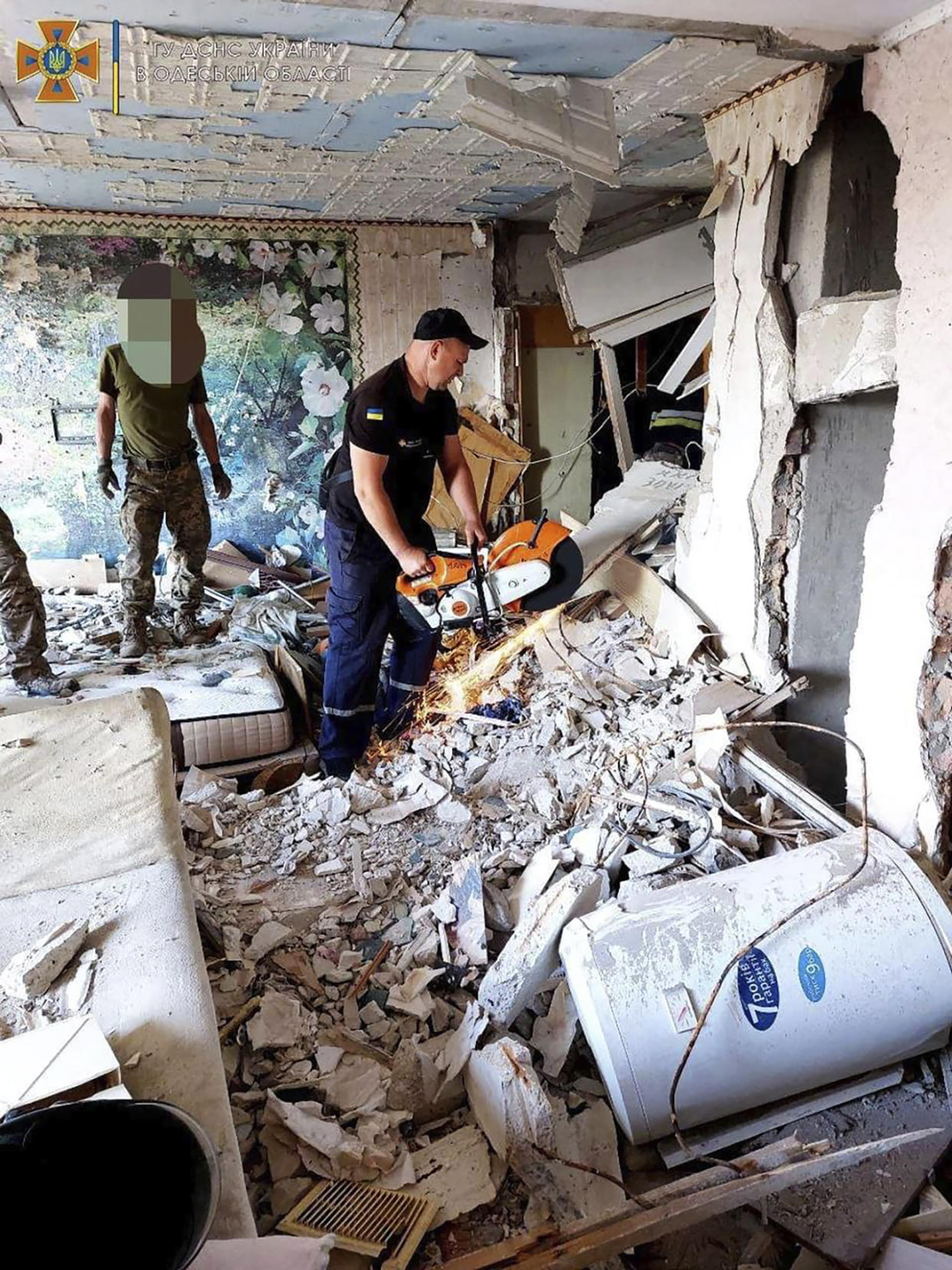 In this photo provided by the Ukrainian Emergency Service, first responders work on a damaged residential building in Odesa, Ukraine, early Friday, July 1, 2022, following Russian missile attacks. Ukrainian authorities said Russian missile attacks on residential buildings in the port city of Odesa have killed more than a dozen people. (Ukrainian Emergency Service via AP)