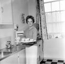 <p>The <em>Mary Poppins </em>star looks polished as she poses in the kitchen of her London apartment with a tea set in 1959.  </p>