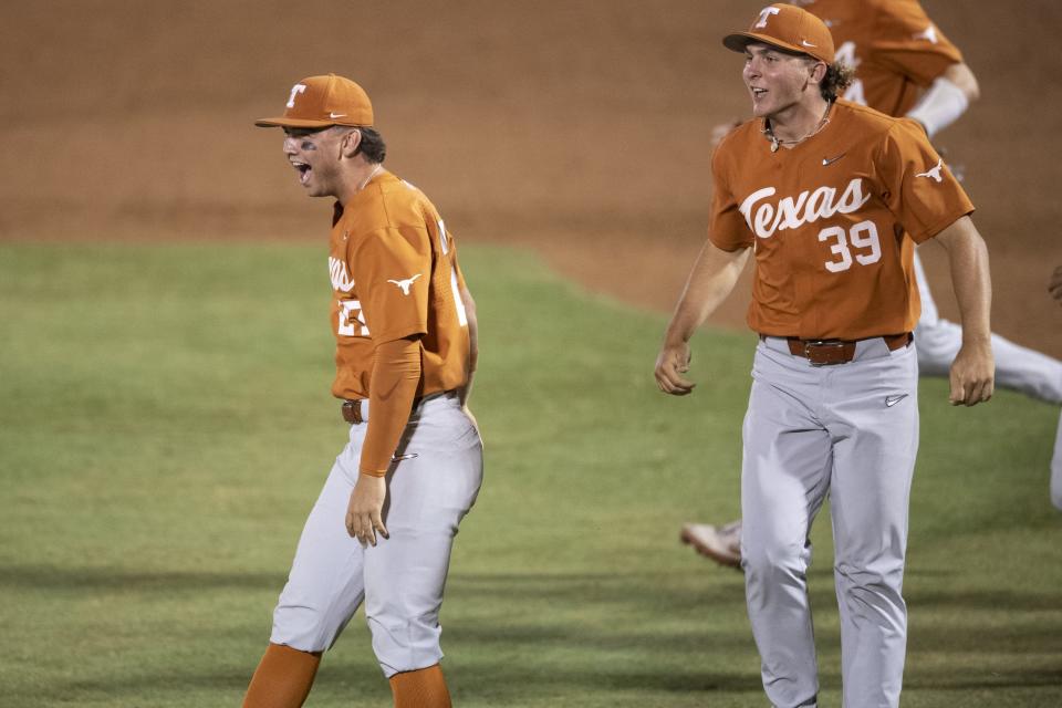 Texas players Jack O'Dowd, left, and Travis Sthele celebrate Sunday night's 11-1 win. The Longhorns had to rally late in Saturday's second game to force Sunday's decisive third game of the Greenville Super Regional.