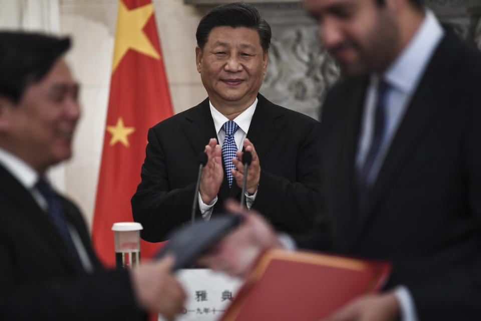 China's President Xi Jinping, centre, looks on as Greek and China's representatives exchange copies of agreements following a signing ceremony, after a joint news conference with Greece's Prime Minister Kyriakos Mitsotakis, at Maximos Mansion in Athens, Monday, Nov. 11, 2019. Xi Jinping is in Greece on a two-day official visit. (Aris Messinis/Pool via AP)