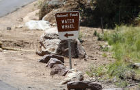 <p>The entrance sign to the Water Wheel recreation area points the the waters where victims were caught in a flash flood along the banks of the East Verde River Monday, July 17, 2017, in Payson, Ariz. The bodies of several children and adults have been found after Saturday’s flash flooding poured over a popular swimming area in the Tonto National Forest. (AP Photo/Ross D. Franklin) </p>