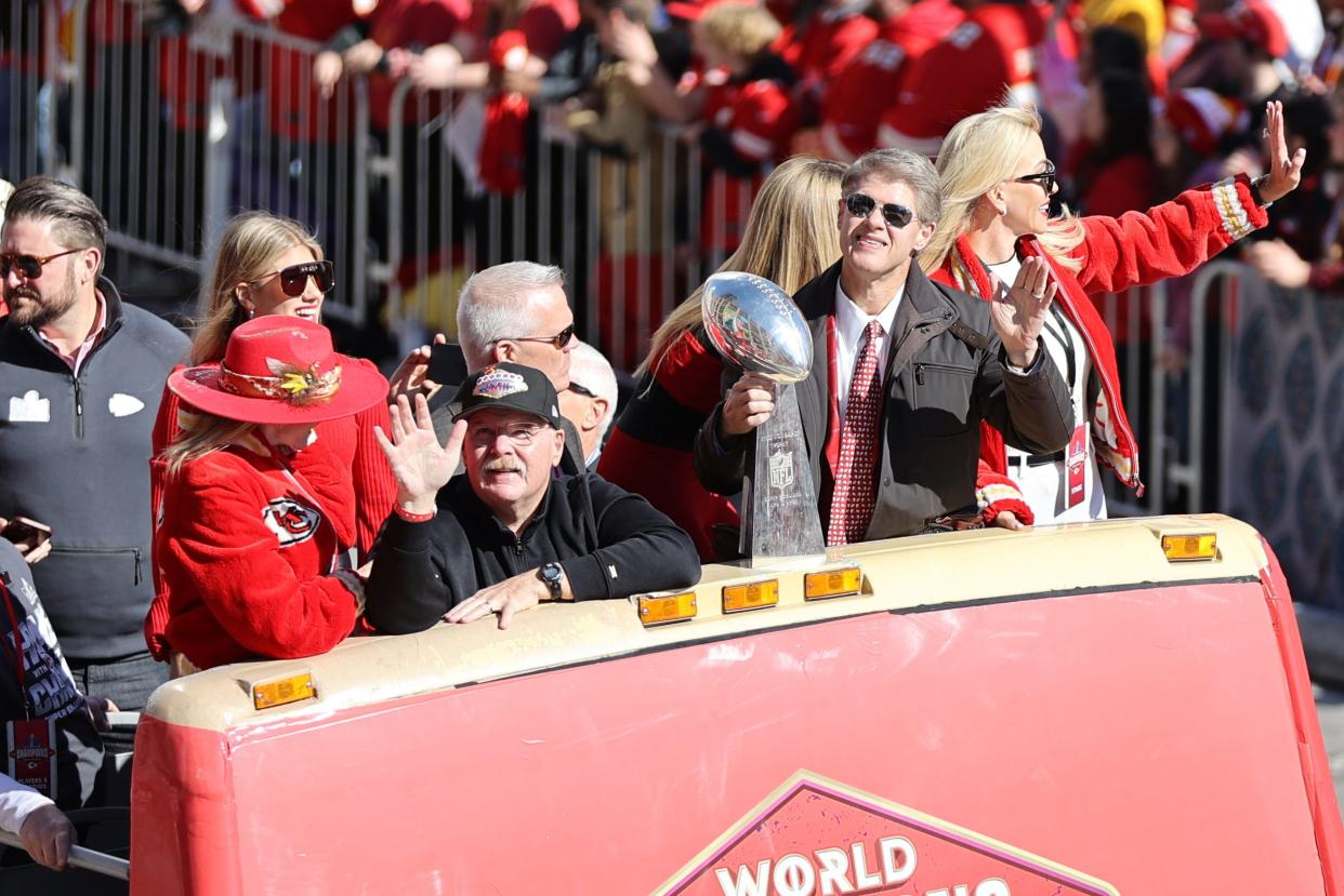 Kansas City Chiefs head coach Andy Reid and owner Clark Hunt wave to the crowd with the Vince Lombardi Trophy.